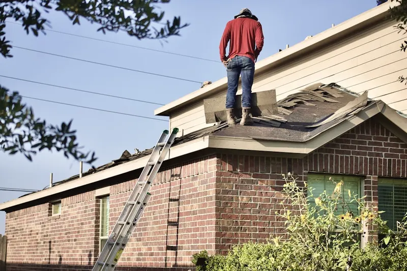 Professional roofer working on a residential roof in Olmstead